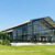 Tenda tipo orangerie com exterior transparente, num relvado, com paredes de vidro