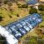 Vista aérea de uma tenda tipo orangerie para eventos ao ar livre, com telhado transparente e cenário de jardim