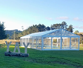 Tenda de eventos com teto transparente montada num relvado verdejante