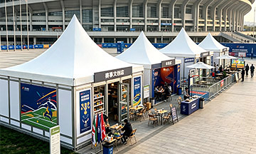 Tendas modulares em forma de pagode com balcões de venda ao público no exterior de um estádio